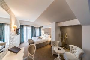 a hotel room with a bed and a living room at Garni Hotel President de Luxe in Kragujevac +62 photos