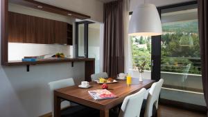 米利尼的住宿－Maistra Select Srebreno Premium Apartments，一间带桌椅和窗户的用餐室