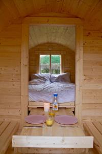 eine Hütte mit einem Bett in der Mitte eines Zimmers in der Unterkunft Helshovens wijnvat in Borgloon