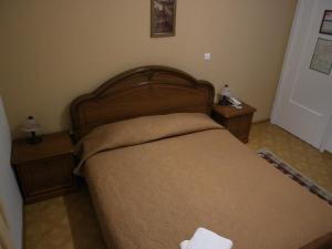 a bedroom with a bed with two night stands and two lamps at Acropolis House in Athens