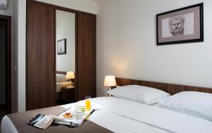a hotel room with a bed with a tray of food on it at Maistra Select Srebreno Premium Apartments in Srebreno