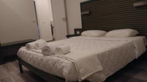 a bedroom with a bed with three towels on it at Suite White in Turin