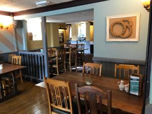 un comedor con mesas y sillas en un restaurante en Bull Inn en Reading