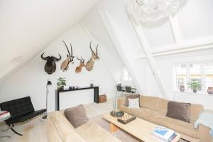 a living room with a couch and some antlers on the wall at Exclusive and central - Private roof top terrace! in Copenhagen