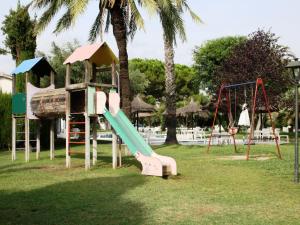 een park met een speeltuin met een glijbaan en schommels bij Villa Service - Alorda park in Calafell