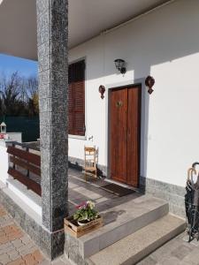 Biały dom z drewnianymi drzwiami i ławką w obiekcie C'era una volta appartamento Queen w mieście Case Nuove