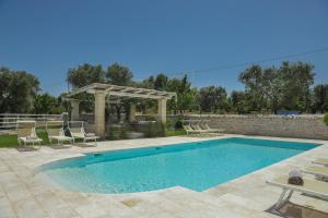 - une piscine avec des chaises et un kiosque dans l'établissement Trulli&Dimore - Casette Pricci, à Castellana Grotte