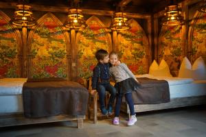 two young children are sitting in a room with beds at Aparthotel MyCologne in Cologne