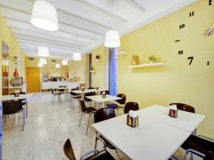 ein Restaurant mit Tischen, Stühlen und Uhren an der Wand in der Unterkunft Casa Del Cigroner in Xàtiva
