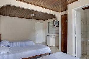 1 dormitorio con 2 camas individuales y baño en Hotel Estrela Do Vale en Ipatinga