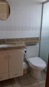y baño con aseo, lavabo y espejo. en Flats em Goiania, en Goiânia