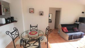 ein Wohnzimmer mit einem Glastisch und Stühlen in der Unterkunft KAZADIDOU - Résidence Grand Cap - Vue Mer et Montagne - Piscine in Le Gosier