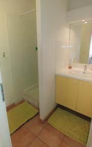 ein Badezimmer mit Waschbecken, Spiegel und Badewanne in der Unterkunft KAZADIDOU - Résidence Grand Cap - Vue Mer et Montagne - Piscine in Le Gosier