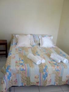 a bed with white pillows and a comforter at Rest. e Pousada Fabiao II in Itacarambi