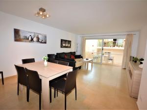 a dining room and living room with a table and chairs at Villa Service - Suïssa 2 in Calafell