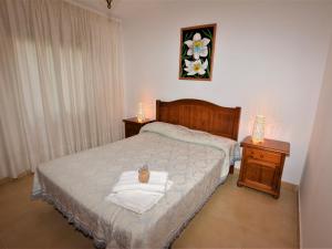 een slaapkamer met een bed met 2 nachtkastjes en een bed met handdoeken bij Villa Service - Suïssa 3 in Calafell