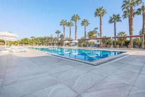 ein Pool in einem Resort mit Palmen in der Unterkunft Sultasa Hotel in Mersin