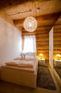 a bedroom with a bed and a chandelier at Luxus-Ferienhaus Blockhaus Chalet Nr 1 Toplage am Feldberg mit Sauna, Outdoor-Hottub, Kamin auf 1300m üM in Feldberg