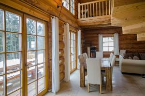 a dining room with a table and chairs and windows at Luxus-Ferienhaus Blockhaus Chalet Nr 1 Toplage am Feldberg mit Sauna, Outdoor-Hottub, Kamin auf 1300m üM in Feldberg