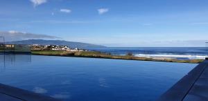 a swimming pool with a view of the ocean at Hotel Verde Mar & SPA in Ribeira Grande