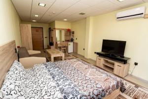 een slaapkamer met een bed en een flatscreen-tv bij Стая за гости Пентагона in Kŭrdzhali
