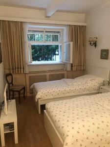 - une chambre avec 2 lits et une fenêtre dans l'établissement Exquisites Gartenapartment in eleganter Jugendstilvilla, à Vienne
