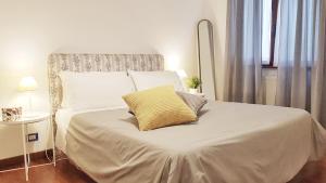 a white bed with a yellow pillow on it at STEFY ROME APARTMENT in Rome