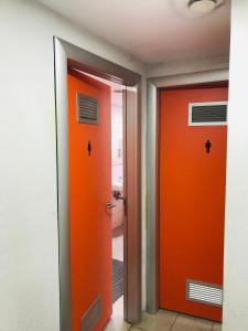 バルセロナにあるホステルズキャットのオレンジ色のドア2つ