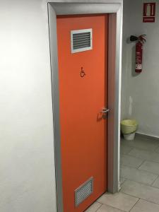 バルセロナにあるホステルズキャットのオレンジ色のドアが備わる客室です。