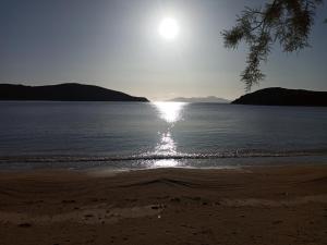 a beach with the sun reflecting on the water at Alexandros by the Beach - Serifos in Livadakia