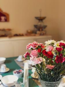 un jarrón lleno de flores sentado en una mesa en Casa Jolanda B&B en Palermo