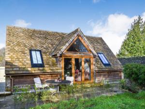 una cabaña con mesa y sillas frente a ella en Sycamore, en Bibury