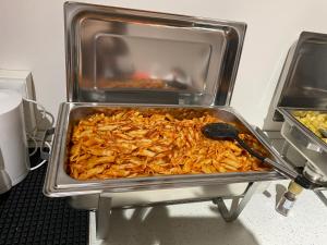 
a pan filled with food on top of a stove at Hightown Hostel in Milan
