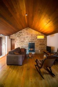 a living room with a couch and a stone fireplace at Casa de Santa Cristina in Alpendurada