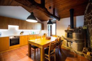 a kitchen with a wooden table and a stone oven at Casa de Santa Cristina in Alpendurada