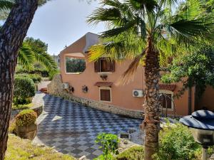 a house with a palm tree in front of it at Villa Plemmyria in Syracuse