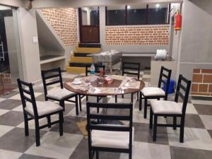 - une salle à manger avec une table, des chaises et des escaliers dans l'établissement The Meadows, à Kodaikānāl