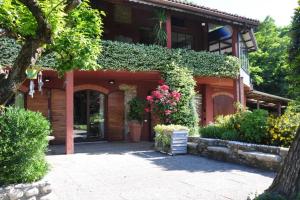 een huis met bloemen en planten ervoor bij la casa rossa nel bosco in Cantù +26 foto's