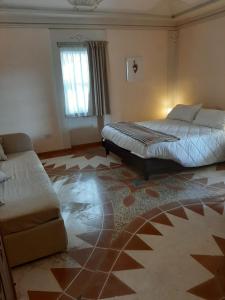 モンテファルコにあるSubretia Residenze Di Campagnaのベッドルーム1室(ベッド2台、ソファ付)