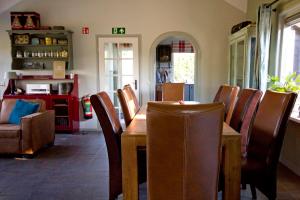een eetkamer met een houten tafel en stoelen bij Het Jachthuus - Vakantiewoning Oscar Hoeve in Ede