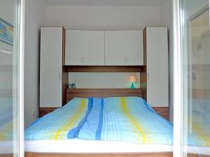 1 dormitorio con 1 cama con rayas azules y amarillas en Apartment Franc, en Njivice