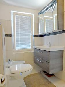 y baño con lavabo, aseo y espejo. en Apartment Franc, en Njivice