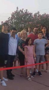 un grupo de personas de pie detrás de una cinta roja en Amocasa en Ragusa