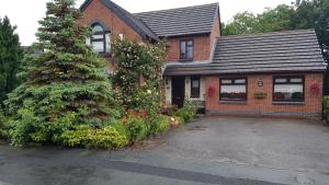 una casa de ladrillo con un árbol delante de ella en Seaton Brook Apartment, en Liverpool