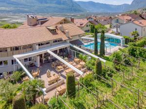 een luchtzicht op een huis met een zwembad bij Tirolerin Garni Hotel in Termeno