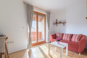 a living room with a red couch and a table at Apartments Valant in Bled