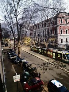 ulica z zaparkowanymi samochodami i pociągiem w mieście w obiekcie AD Trastevere Guest House - by AD Roma w Rzymie