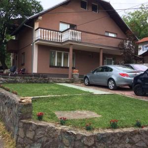 a house with cars parked in front of it at Apartmani Popovic in Vrdnik