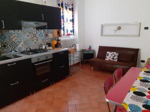 uma cozinha com uma mesa e um sofá num quarto em La casa sulla vecchia riva em Ferrara