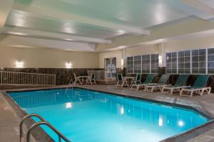 a pool at a hotel with chairs and tables at La Quinta by Wyndham Dodge City in Dodge City
